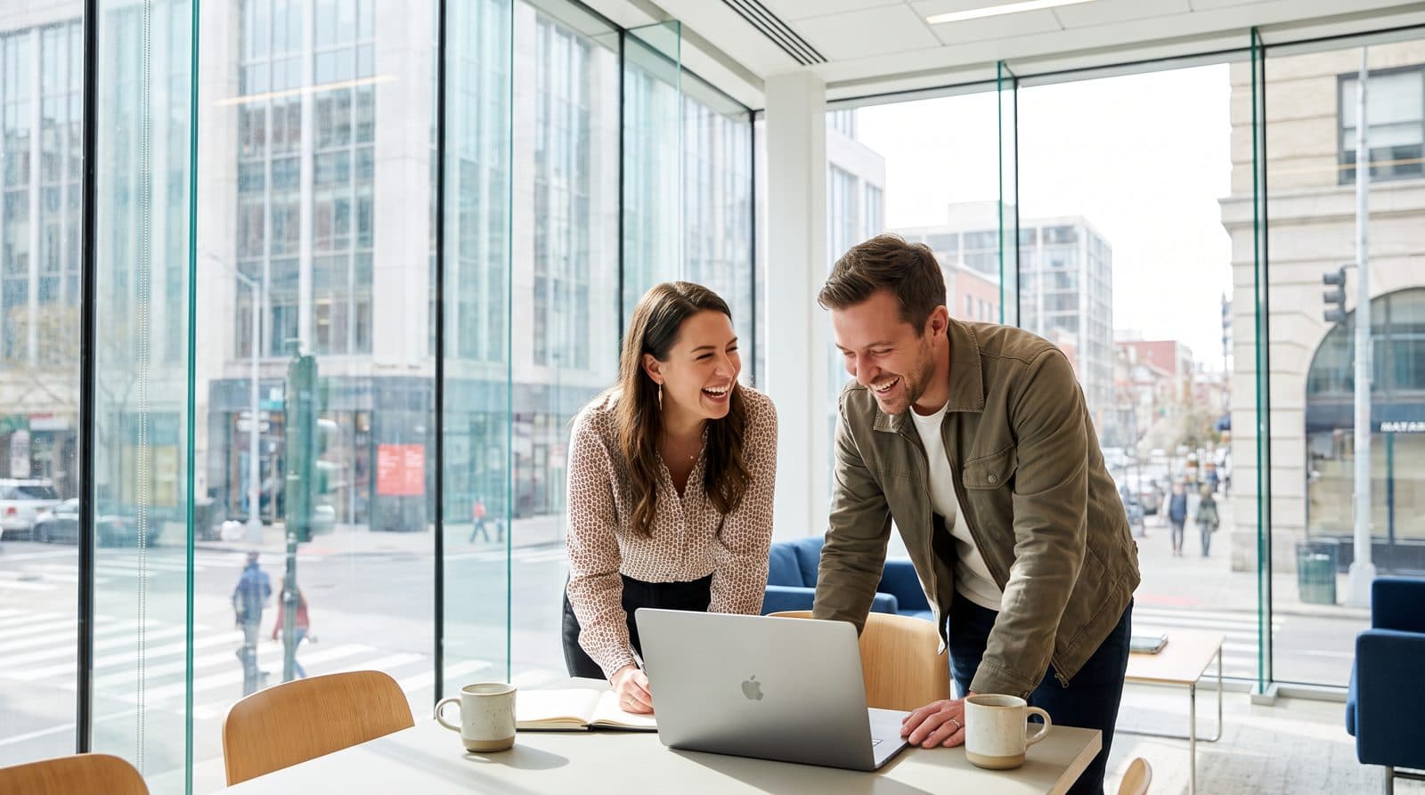 An accountant and a business owner laugh in a bright office